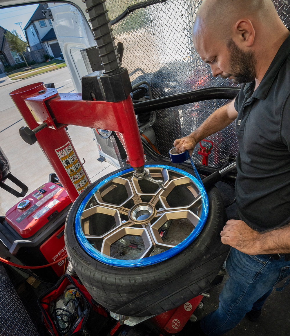 Mechanic Installing Tire on Rim in the Garage2Go Mobile Service Van